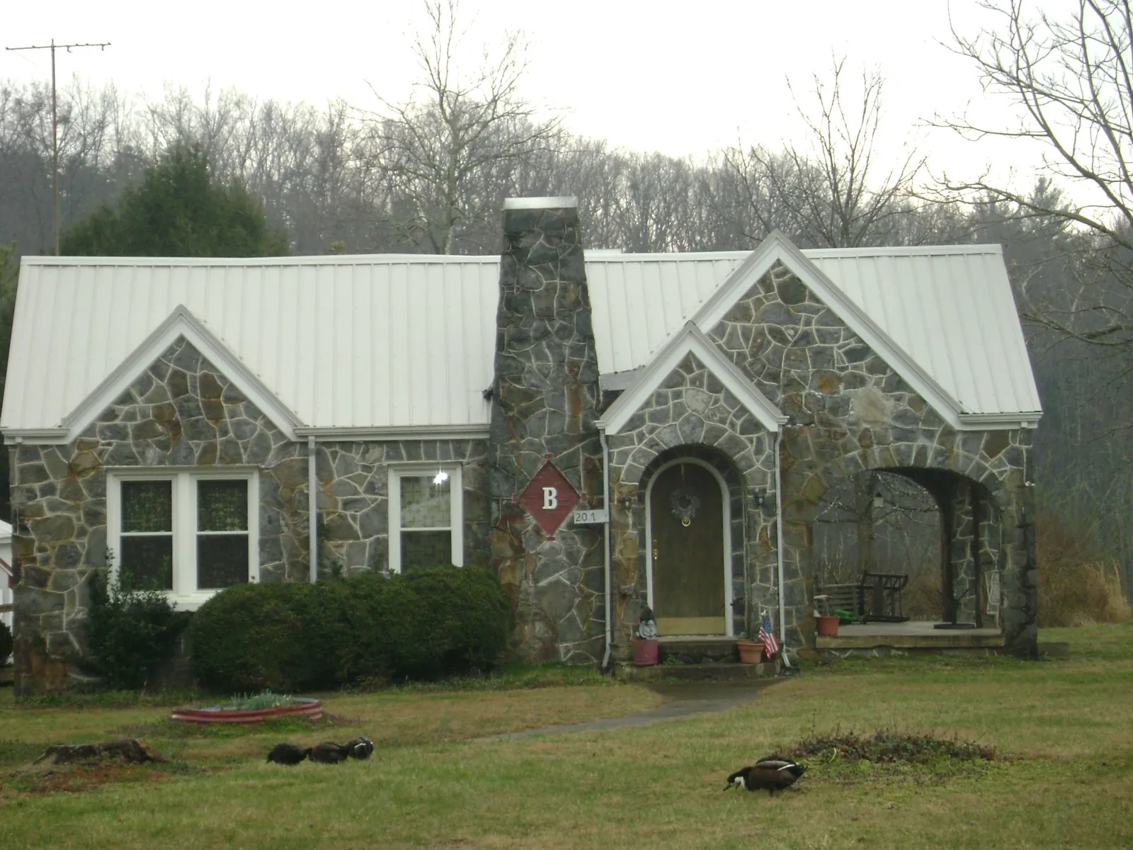 White metal roof on a stone cottage with steep gables in Waynesburg